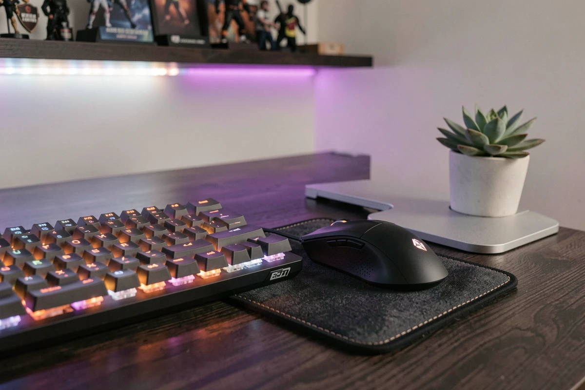 Détail de bureau gaming avec clavier mécanique rétroéclairé, souris gaming et décoration esports minimaliste