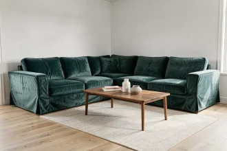 Housse de canapé d'angle convertible en velours bleu sarcelle dans un salon scandinave lumineux